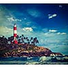 Vintage retro hipster style travel image of old lighthouse and waves of  sea. Kovalam (Vizhinjam) Kerala, India