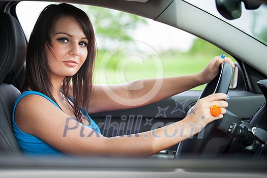 Pretty young woman driving her new car