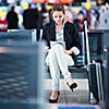 Young female passenger at the airport, using her tablet computer while waiting for her flight (color toned image)