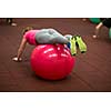 Group people in a pilates class at the gym - young woman with gymball at fitness training (shallow DOF, color toned image)