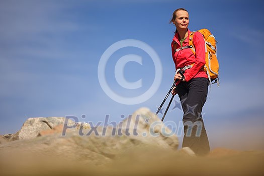 Pretty, young female hiker going uphill Pretty, young female hiker going uphill