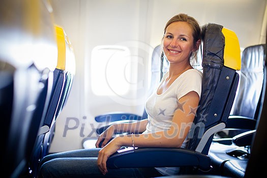 Pretty, young female passenger on board of an aircraft while on the flight