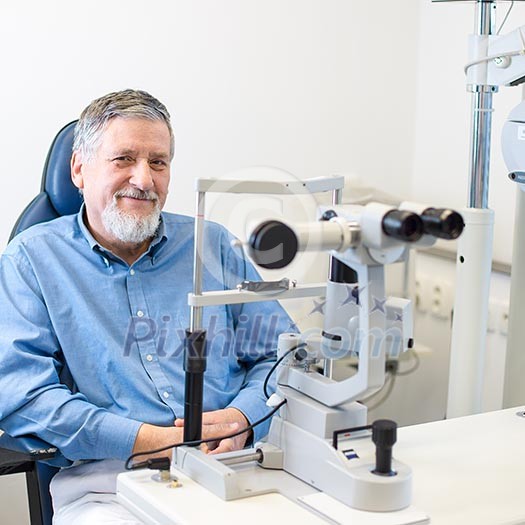 Optometry concept - Senior patient sitting the exmanination chair , before having his eyes examined by an eye doctor, smiling, looking happy