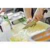 Handsome chef dressed in white uniform decorating pasta salad and seafood fish in modern kitchen