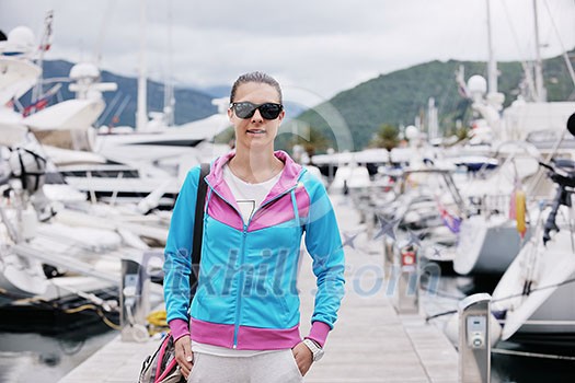 relaxed young woman walking in marina with yacht boats in bacground relaxed young woman walking in marina with yacht boats in bacground