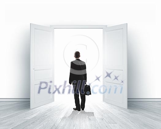 Image of businessman standing in front of opened door