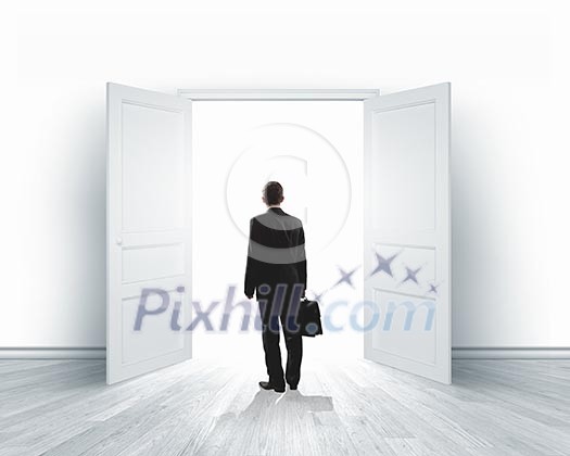Image of businessman standing in front of opened door Image of businessman standing in front of opened door
