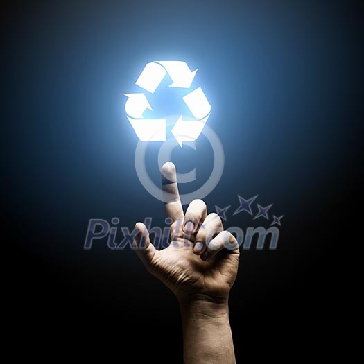 Human hand pointing with finger at recycle symbol Human hand pointing with finger at recycle symbol