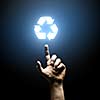 Human hand pointing with finger at recycle symbol