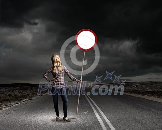 Young woman in casual holding road sign Young woman in casual holding road sign