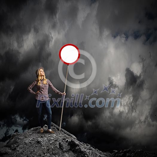 Young woman in casual holding road sign Young woman in casual holding road sign