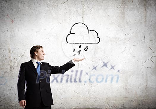 Young businessman holding palm to catch rain drops Young businessman holding palm to catch rain drops