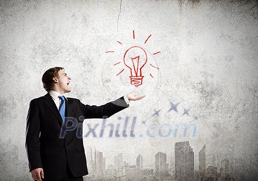 Young businessman holding electric bulb in palm Young businessman holding electric bulb in palm