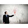 Young businessman holding electric bulb in palm