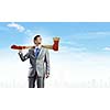 Young businessman holding big axe on shoulder