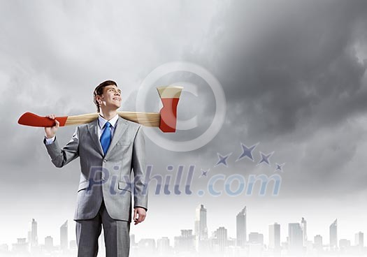 Young businessman holding big axe on shoulder