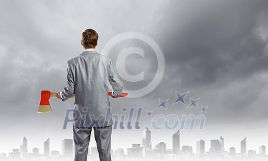 Rear view of businessman holding big axe