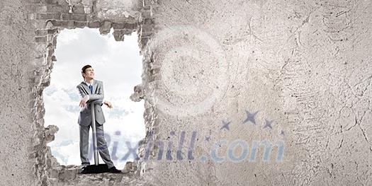 Young businessman with big hammer against wall Young businessman with big hammer against wall