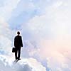 Back view of businessman standing on cloud high in sky