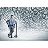 Young businessman with wrench against mechanism background