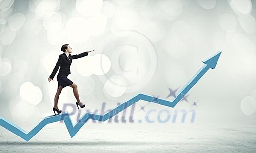 Young cheerful businesswoman walking on increasing graph