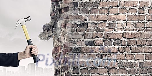 Close up of female hand crashing wall with hammer