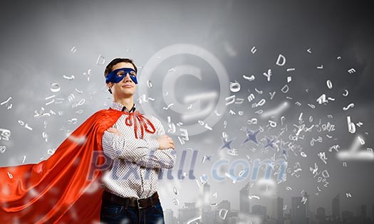 Young confident superman in mask and cape