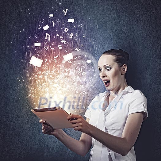 Young businesswoman looking astonished into tablet pc