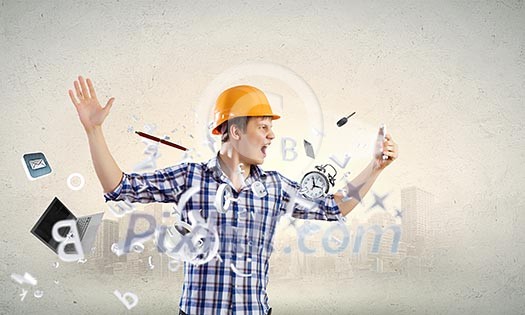 Image of young man engineer screaming angrily in mobile phone