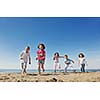 group of happy child on beach who have fun and play games