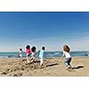 group of happy child on beach who have fun and play games