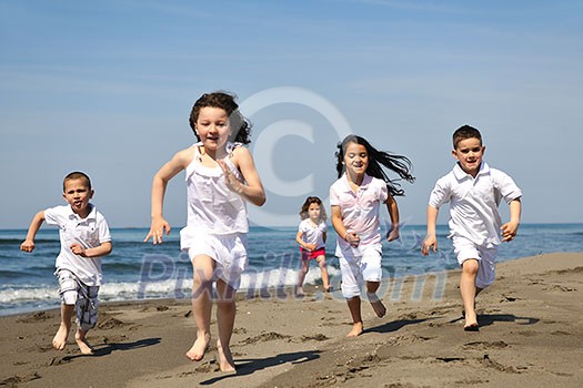 group of happy child on beach who have fun and play games