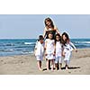 group portrait of happy childrens with young female  teacher on beach