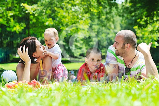 happy young couple with their children have fun at beautiful park outdoor in nature
