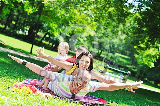 happy young couple with their children have fun at beautiful park outdoor in nature