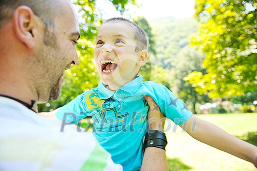family father and son have fun at park on summer season and representing happines concept