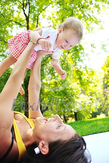 happy young woman and baby have fun while playing in beautiful bright park at summer season