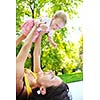 happy young woman and baby have fun while playing in beautiful bright park at summer season