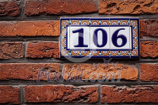 Decorated house number on brick wall in Europe. Bruges (Brugge), Belgium