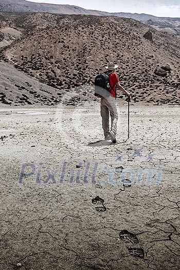 Single mountaineer trekker walking in Himalayas mountains ecotourism concept in India Single mountaineer trekker walking in Himalayas mountains ecotourism concept in India