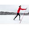 Cross-country skiing: young woman cross-country skiing on a  winter day (motion blurred image)