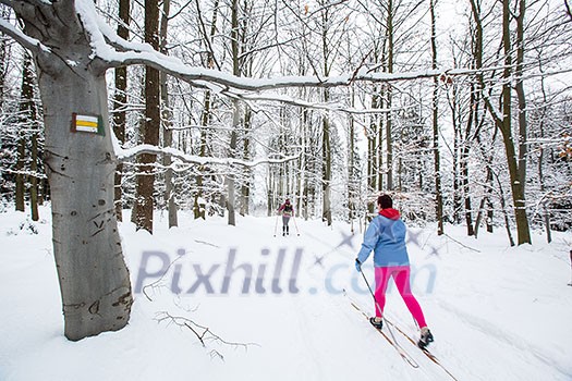 Cross-country skiing: two women cross-country skiing on a  winter day (motion blurred image)