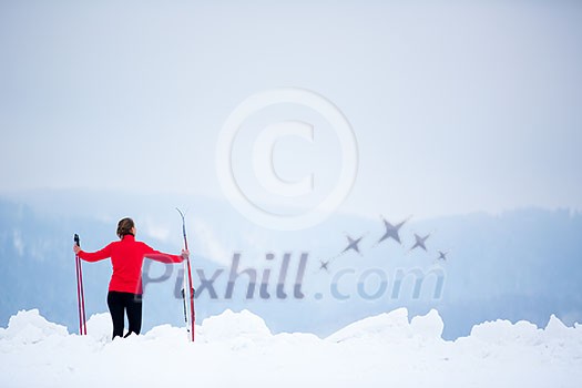 Cross-country skiing: young woman cross-country skiing on a  winter day (motion blurred image)