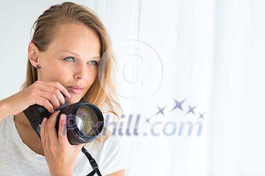Pretty, female photographer with digital camera - DSLR and a huge telephoto lens (color toned image; shallow DOF) Pretty, female photographer with digital camera - DSLR and a huge telephoto lens (color toned image; shallow DOF)