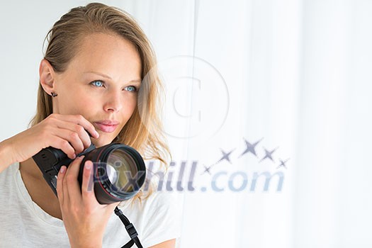 Pretty, female photographer with digital camera - DSLR and a huge telephoto lens (color toned image; shallow DOF)