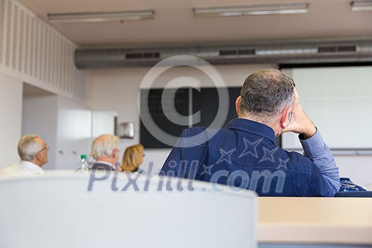 Elderly people are sitting in a classroom, learning something new despite their age Elderly people are sitting in a classroom, learning something new despite their age