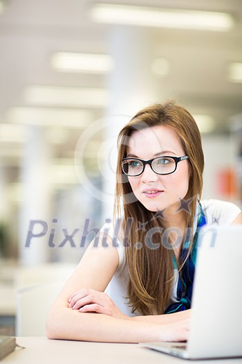 Pretty, female college student in a library, looking for a book (shallow DOF; color toned image)