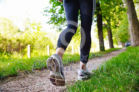 Young beautiful  woman jogging in summer park. Woman in sport outdoors health concept