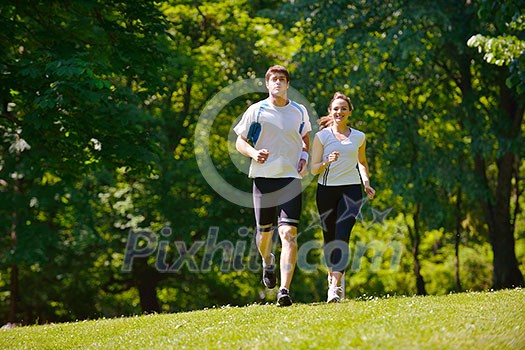 Young couple jogging in park at morning. Health and fitness.