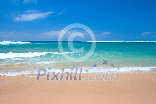 Peaceful beach scene with ocean and blue sky